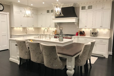 Example of a transitional l-shaped dark wood floor open concept kitchen design in DC Metro with a farmhouse sink, beaded inset cabinets, white cabinets, quartz countertops, white backsplash, subway tile backsplash, stainless steel appliances and an island