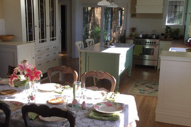 Immagine di una cucina american style di medie dimensioni con lavello stile country, ante a filo, ante bianche, top in legno, paraspruzzi beige, elettrodomestici in acciaio inossidabile e parquet chiaro