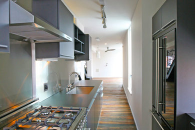 Example of a mid-sized urban galley dark wood floor and brown floor enclosed kitchen design in Philadelphia with an undermount sink, flat-panel cabinets, gray cabinets, concrete countertops, stainless steel appliances and no island