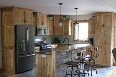 Urige Küche mit profilierten Schrankfronten, hellen Holzschränken und Quarzwerkstein-Arbeitsplatte in Sonstige