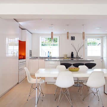 Bespoke, basement, white-gloss kitchen with orange accents