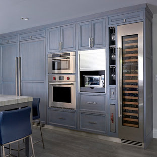 Large transitional eat-in kitchen appliance - Example of a large transitional porcelain tile eat-in kitchen design in New York with a farmhouse sink, recessed-panel cabinets, light wood cabinets, quartzite countertops, gray backsplash, ceramic backsplash, paneled appliances and an island