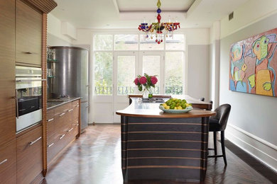 Diseño de cocina actual con armarios con paneles lisos, puertas de armario de madera oscura y electrodomésticos de acero inoxidable