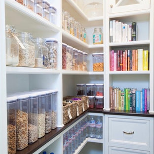 Design ideas for a medium sized traditional l-shaped kitchen pantry in London with dark hardwood flooring, black floors, recessed-panel cabinets and brown worktops.
