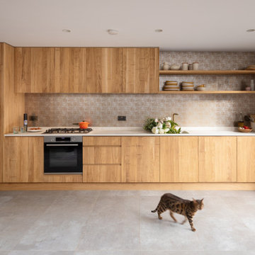 Bespoke kitchen with band-sawn cabinetry and golden glass splashback