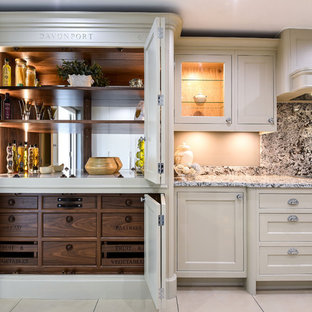 Traditional kitchen pantry in Berkshire with recessed-panel cabinets, beige cabinets, stone slab splashback, black appliances, beige floors and grey worktops.
