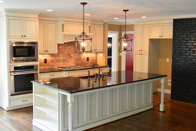 Inspiration for a large timeless l-shaped dark wood floor open concept kitchen remodel in Raleigh with a farmhouse sink, white cabinets and an island