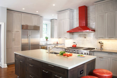 Mid-sized trendy l-shaped dark wood floor eat-in kitchen photo in New York with an undermount sink, shaker cabinets, gray cabinets, solid surface countertops, white backsplash, stone tile backsplash, stainless steel appliances and an island
