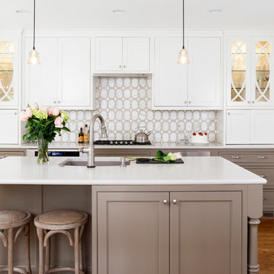 Example of a mid-sized transitional l-shaped medium tone wood floor eat-in kitchen design in DC Metro with white cabinets, white backsplash, stainless steel appliances, an island, an undermount sink and recessed-panel cabinets