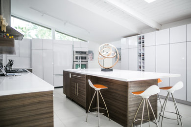 Example of a minimalist kitchen design in Seattle with flat-panel cabinets and an island