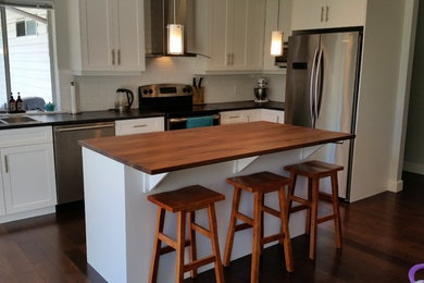 Elegant kitchen photo in Vancouver with shaker cabinets, white cabinets, laminate countertops, white backsplash, ceramic backsplash and an island