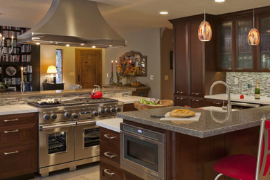 Large transitional l-shaped eat-in kitchen photo in Sacramento with recessed-panel cabinets, dark wood cabinets, quartzite countertops, multicolored backsplash, stainless steel appliances and a peninsula