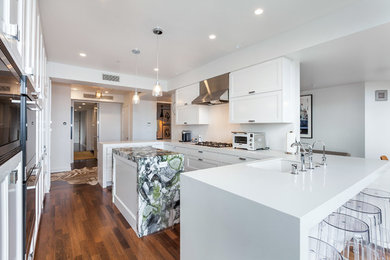 Inspiration for a large modern u-shaped dark wood floor and brown floor enclosed kitchen remodel in Los Angeles with an undermount sink, recessed-panel cabinets, white cabinets, quartz countertops, stainless steel appliances, an island and white countertops