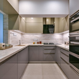 Inspiration for an asian u-shaped kitchen in Mumbai with an undermount sink, flat-panel cabinets, grey cabinets, beige splashback, stainless steel appliances, beige floor and beige benchtop.