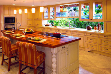 Design ideas for an expansive mediterranean kitchen in Hawaii with a submerged sink, beaded cabinets, glass tiled splashback, integrated appliances, marble flooring and an island.