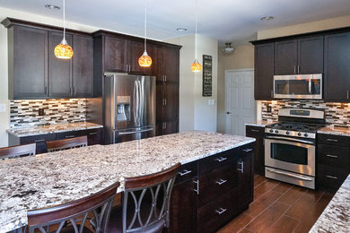 Example of a large transitional l-shaped eat-in kitchen design in Philadelphia with an undermount sink, granite countertops, multicolored backsplash, glass tile backsplash, stainless steel appliances and an island