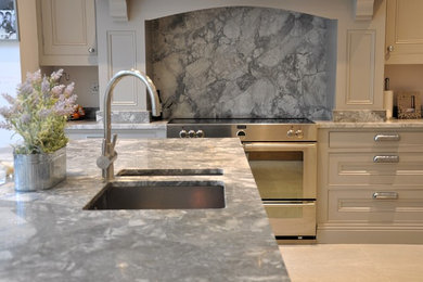 This is an example of a large classic l-shaped kitchen/diner in Essex with shaker cabinets, grey cabinets, marble worktops, grey splashback, marble splashback, stainless steel appliances, an island and grey worktops.