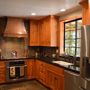 Design ideas for a mid-sized arts and crafts l-shaped eat-in kitchen in Sacramento with a single-bowl sink, raised-panel cabinets, medium wood cabinets, quartzite benchtops, grey splashback, stone tile splashback, stainless steel appliances, slate floors, brown floor and a peninsula.