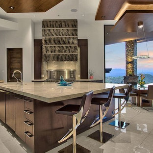 Diseño de cocina de estilo americano, abierta, con armarios con paneles lisos, puertas de armario de madera en tonos medios, electrodomésticos de acero inoxidable, una isla, suelo gris y encimeras grises