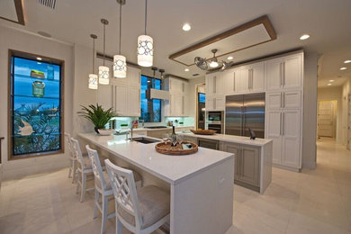 Example of a large transitional u-shaped eat-in kitchen design in Tampa with recessed-panel cabinets, white cabinets, quartz countertops, white backsplash, glass tile backsplash and two islands