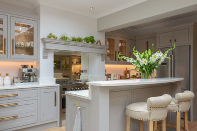 Inspiration for a large open plan kitchen in London with glass sheet splashback and an island.