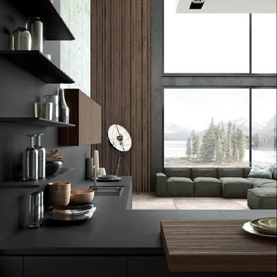Inspiration for a huge contemporary l-shaped light wood floor and beige floor open concept kitchen remodel in San Francisco with a drop-in sink, flat-panel cabinets, black cabinets, solid surface countertops, black backsplash, stone slab backsplash, paneled appliances, no island and black countertops