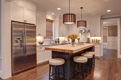 Inspiration for a mid-sized contemporary l-shaped medium tone wood floor open concept kitchen remodel in Detroit with subway tile backsplash, stainless steel appliances, an undermount sink, shaker cabinets, white cabinets, wood countertops, white backsplash and an island