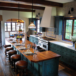 This is an example of a mediterranean open plan kitchen in San Diego with an undermount sink, raised-panel cabinets, green cabinets, marble benchtops, ceramic splashback, panelled appliances, dark hardwood floors and with island.