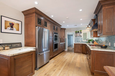 Mid-sized elegant galley light wood floor and brown floor eat-in kitchen photo in San Diego with an undermount sink, recessed-panel cabinets, brown cabinets, granite countertops, blue backsplash, porcelain backsplash, stainless steel appliances, no island and white countertops