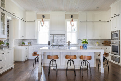 Example of a farmhouse kitchen design in Jacksonville with a farmhouse sink, stainless steel appliances, beaded inset cabinets and quartz countertops
