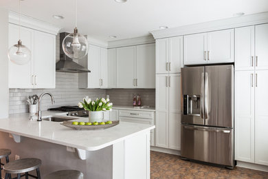 Example of a trendy kitchen design in DC Metro with a drop-in sink, white cabinets, white backsplash, stainless steel appliances and white countertops