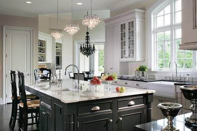 Large transitional l-shaped dark wood floor eat-in kitchen photo in New York with a farmhouse sink, recessed-panel cabinets, black cabinets, marble countertops, beige backsplash, ceramic backsplash, paneled appliances and an island