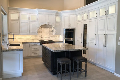 Eat-in kitchen - mid-sized transitional u-shaped porcelain tile and gray floor eat-in kitchen idea in Phoenix with an undermount sink, raised-panel cabinets, white cabinets, granite countertops, porcelain backsplash, stainless steel appliances, an island and white countertops