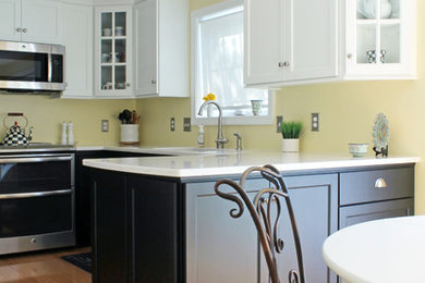 Example of a small transitional u-shaped medium tone wood floor and brown floor eat-in kitchen design in Other with an undermount sink, recessed-panel cabinets, black cabinets, quartz countertops, yellow backsplash, stainless steel appliances and a peninsula