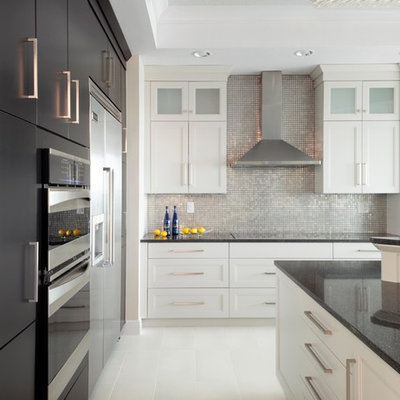 Mid-sized trendy ceramic tile and white floor kitchen photo in Miami with recessed-panel cabinets, white cabinets, quartz countertops, metallic backsplash, mosaic tile backsplash, stainless steel appliances and an island