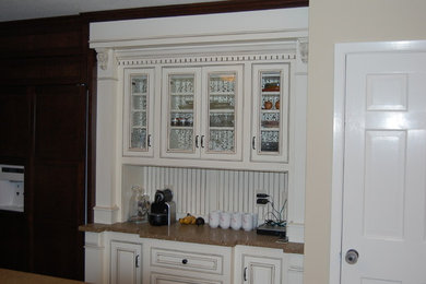 Example of an arts and crafts kitchen design in Minneapolis with a farmhouse sink, beaded inset cabinets, dark wood cabinets and concrete countertops