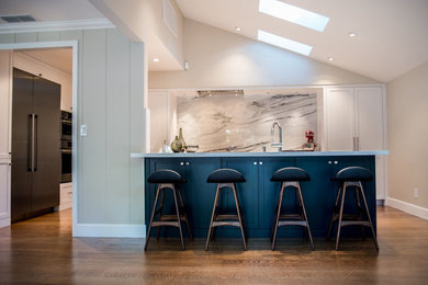 Eat-in kitchen - large transitional medium tone wood floor eat-in kitchen idea in Sacramento with an undermount sink, shaker cabinets, white cabinets, stone slab backsplash, stainless steel appliances and quartzite countertops