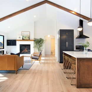 Large scandinavian open concept kitchen appliance - Example of a large danish u-shaped light wood floor and beige floor open concept kitchen design in Grand Rapids with a farmhouse sink, shaker cabinets, quartzite countertops, white backsplash, subway tile backsplash, black appliances, an island, white countertops and black cabinets