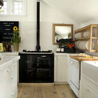 Inspiration for a scandinavian kitchen in Portland with a farmhouse sink, tile benchtops, open cabinets, white cabinets, black appliances and white splashback.