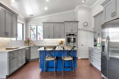 Example of a mid-sized transitional u-shaped eat-in kitchen design in Phoenix with shaker cabinets, stainless steel appliances and an island