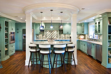 Large trendy u-shaped medium tone wood floor eat-in kitchen photo in Charleston with an undermount sink, recessed-panel cabinets, blue cabinets, granite countertops, multicolored backsplash, ceramic backsplash, stainless steel appliances and an island