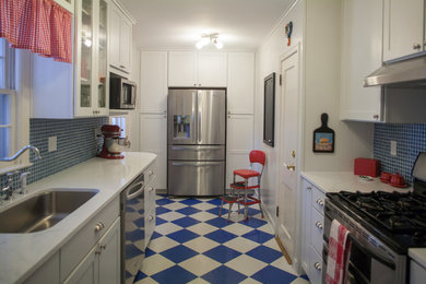 Mid-sized elegant galley vinyl floor and multicolored floor enclosed kitchen photo in Kansas City with white cabinets, an undermount sink, shaker cabinets, quartzite countertops, blue backsplash, glass tile backsplash, paneled appliances and no island