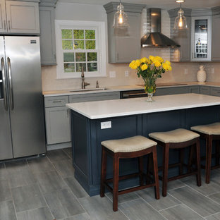 Large transitional eat-in kitchen designs - Example of a large transitional l-shaped gray floor and porcelain tile eat-in kitchen design in Philadelphia with recessed-panel cabinets, gray cabinets, white backsplash, stainless steel appliances, an island, an undermount sink, quartz countertops, ceramic backsplash and white countertops