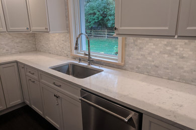 Mid-sized transitional u-shaped dark wood floor and brown floor eat-in kitchen photo in Philadelphia with an undermount sink, recessed-panel cabinets, white cabinets, quartzite countertops, gray backsplash, subway tile backsplash, stainless steel appliances, an island and white countertops