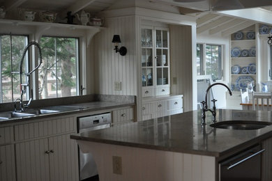 ポートランド(メイン)にあるカントリー風のおしゃれなキッチン (ダブルシンク、白いキャビネット、シルバーの調理設備、無垢フローリング) の写真
