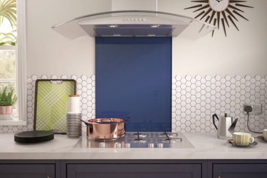 Moderne Küche mit flächenbündigen Schrankfronten, weißen Schränken, Küchenrückwand in Blau und Glasrückwand in Hertfordshire