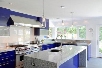 Example of a trendy kitchen design in Ottawa with a double-bowl sink, flat-panel cabinets, blue cabinets, glass sheet backsplash, quartz countertops and stainless steel appliances