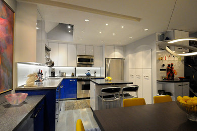 Foto på ett mellanstort funkis kök, med en undermonterad diskho, släta luckor, vitt stänkskydd, glaspanel som stänkskydd, rostfria vitvaror, en köksö, vita skåp, granitbänkskiva, mörkt trägolv och grått golv
