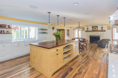 Mid-sized country galley medium tone wood floor and brown floor eat-in kitchen photo in DC Metro with a farmhouse sink, flat-panel cabinets, white cabinets, wood countertops, multicolored backsplash, paneled appliances, an island and brown countertops
