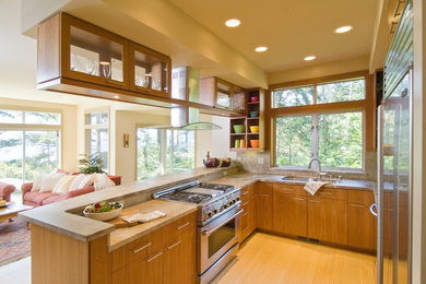 Transitional u-shaped bamboo floor open concept kitchen photo in Seattle with an undermount sink, flat-panel cabinets, medium tone wood cabinets, granite countertops, beige backsplash, stone slab backsplash and stainless steel appliances
